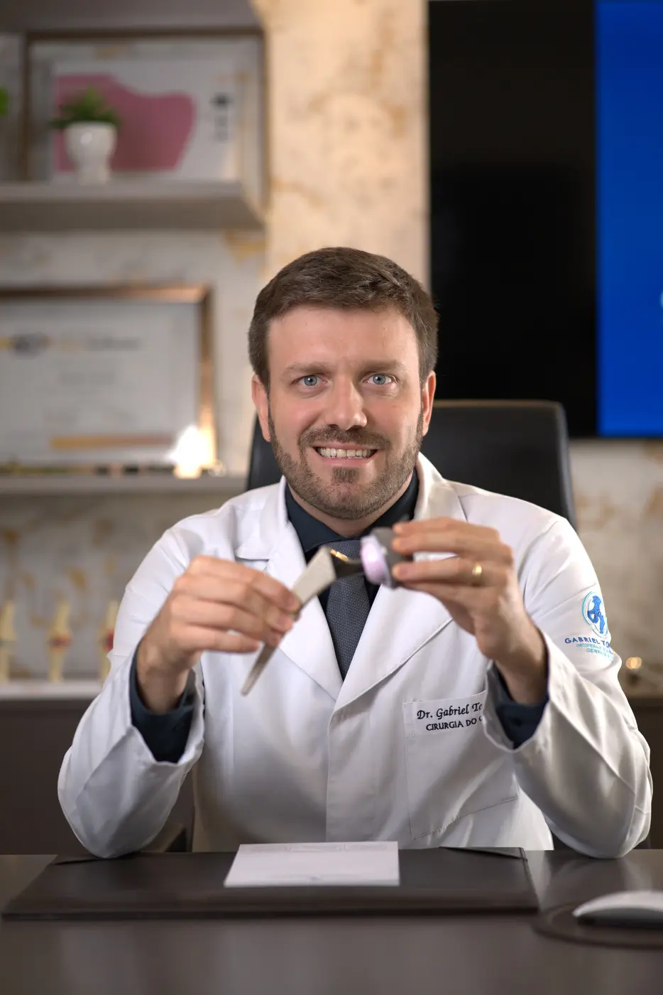Dr. Gabriel Tomazini sorrindo em seu consultório no Centro Médico Itupava, em Curitiba